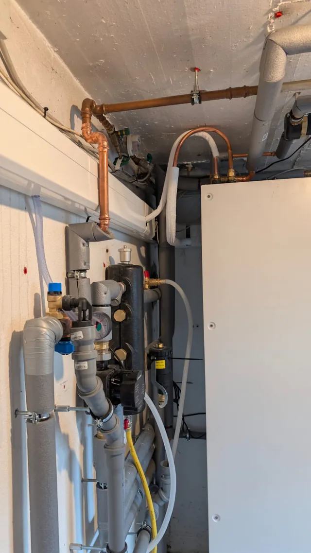 Pumpengruppe mit Absperrungen und Kupferleitungen am Speicher im Technikraum