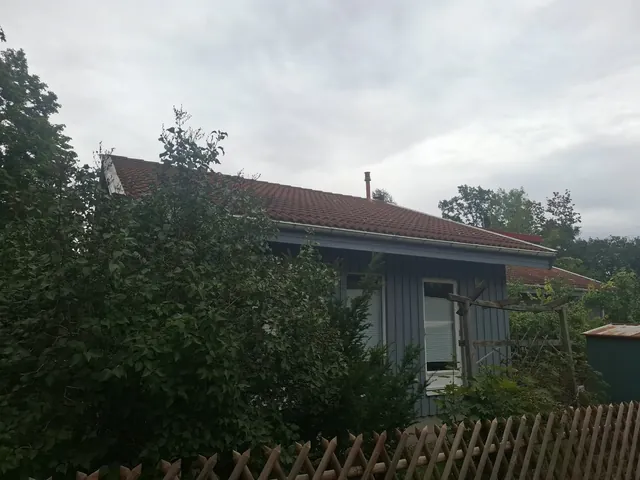 Wohngebäude mit Ziegeldach vor Beginn der Arbeiten, Aufnahme vom Grundstück