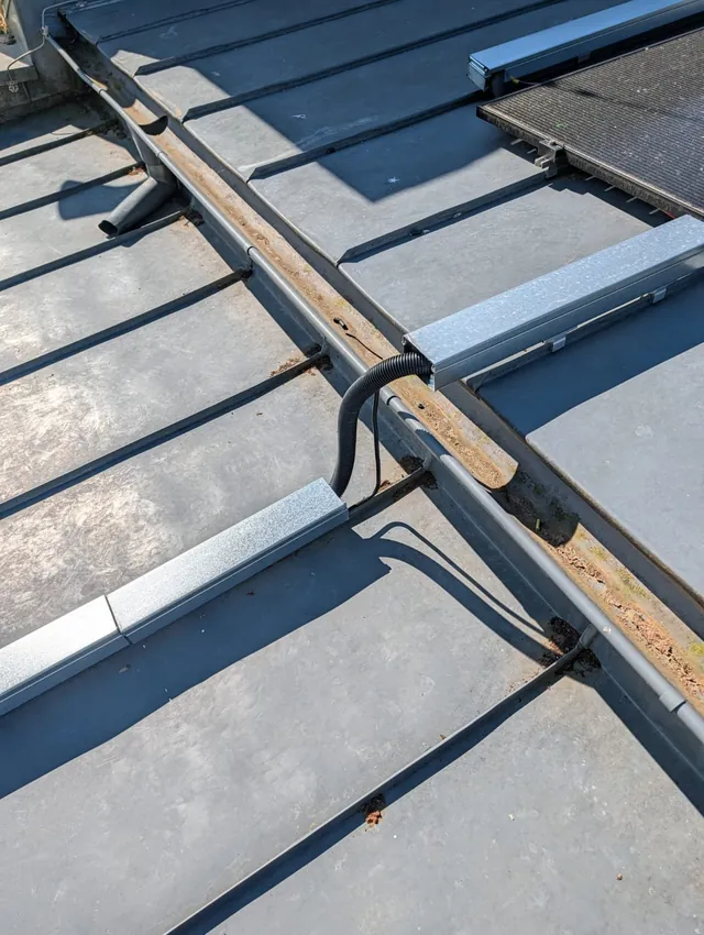 Unterkonstruktion der Flachdachanlage mit Schienen und Kabelführung vor der Modulmontage
