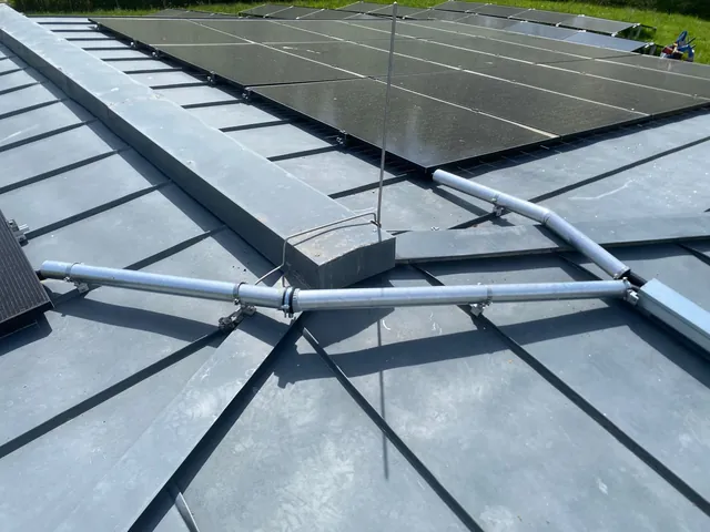 Fertig belegtes Stehfalzdach mit Photovoltaikmodulen und Blitzschutz-Fangstangen
