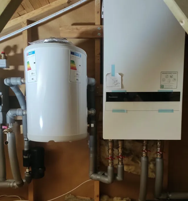Wärmepumpen-Innengerät mit danebenliegendem Pufferspeicher, darunter die abgesperrten und gedämmten Anschlussleitungen